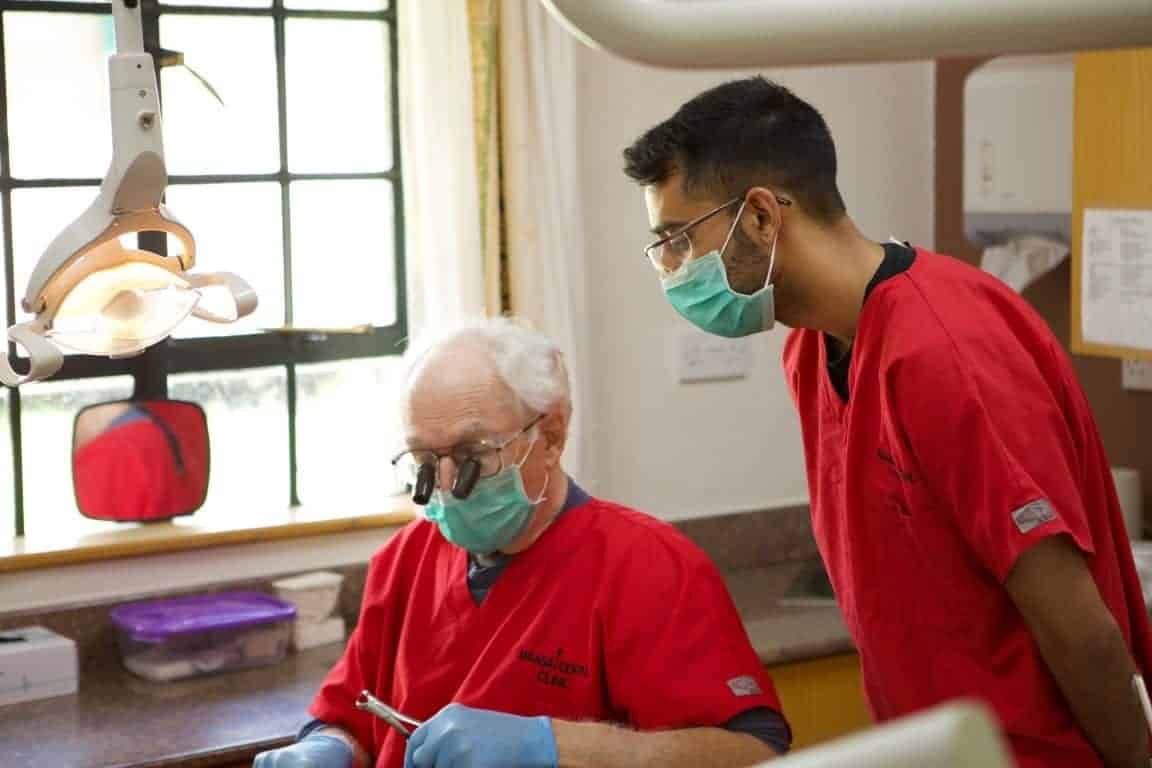 Dentist and assistant cleaning teeth